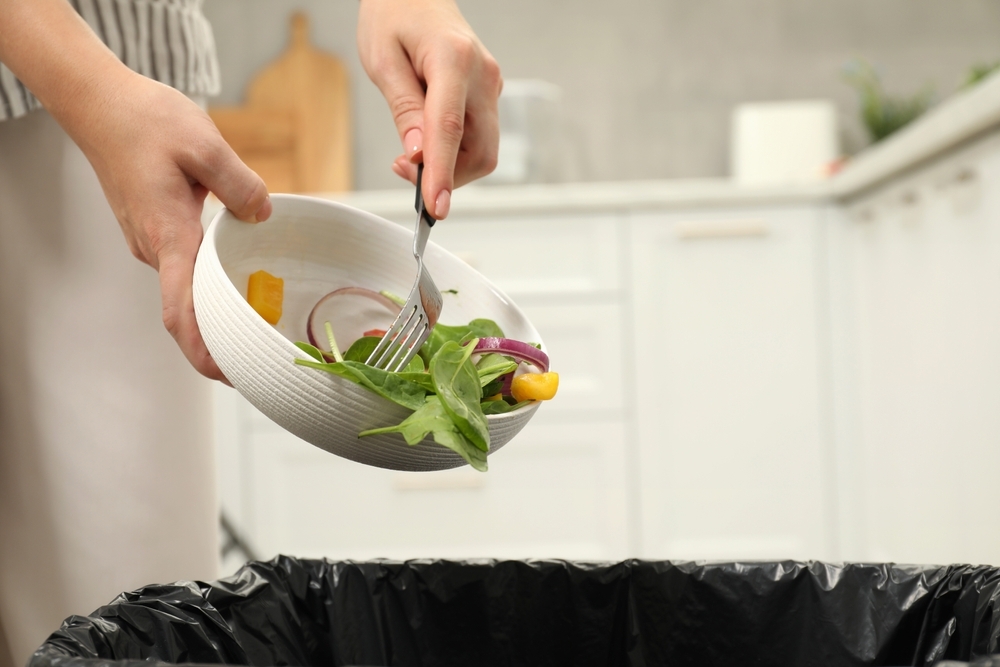 Food being pushed into a bin