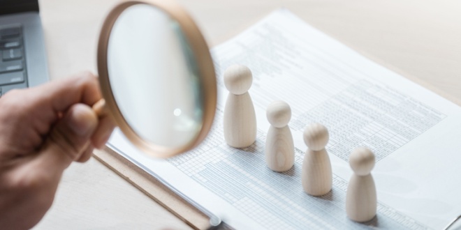 four figures under magnifying glass