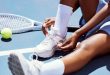 woman sat next to tennis racket