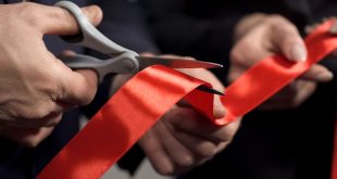 A ribbon being cut with scissors