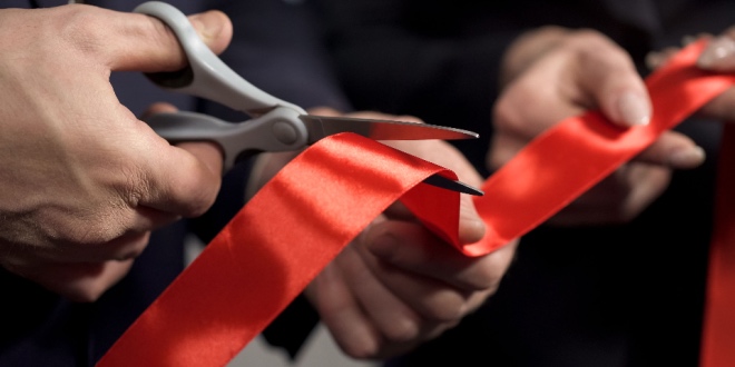 A ribbon being cut with scissors