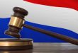 A court hammer with the Dutch flag in the background