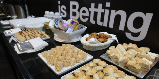 Tray of sandwiches and other foods in front of a sign reading betting