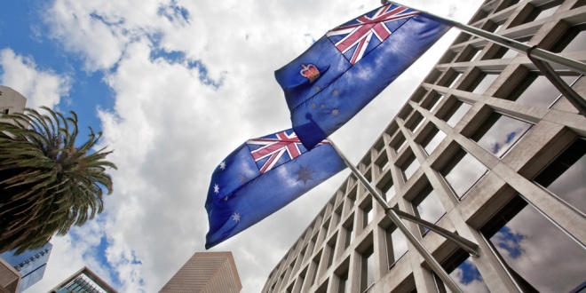 Australian flags flying over a government building in Melbourne, Entain is currently facing an investigation in Australia from the AUSTRAC government agency