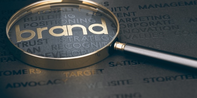 A magnifying glass over the world branding, the task of Allwyn's new Chief Brand Officer
