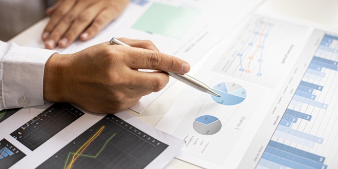 A man looking over graphs and charts, indicative of the roles of a CFO that Raketech is trying to fill