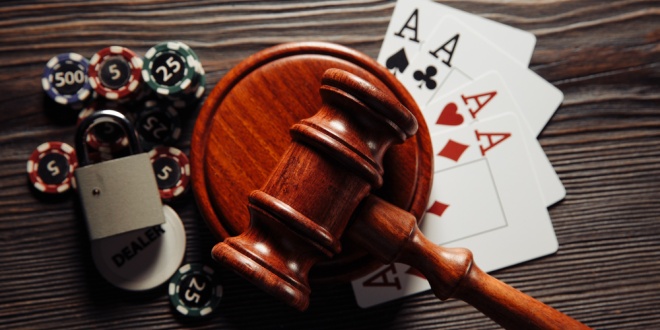 A judge's gavel next to casino chips and cards, representing illegal casinos and illegal gambling