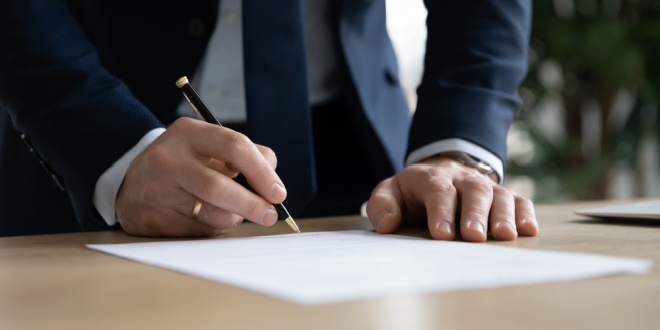 A man signing a contract, symbolic of EveryMatrix's new Managing Director