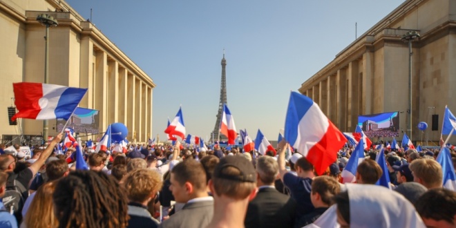 Paris as people march waving French flags, symbolising predictions markets in the country