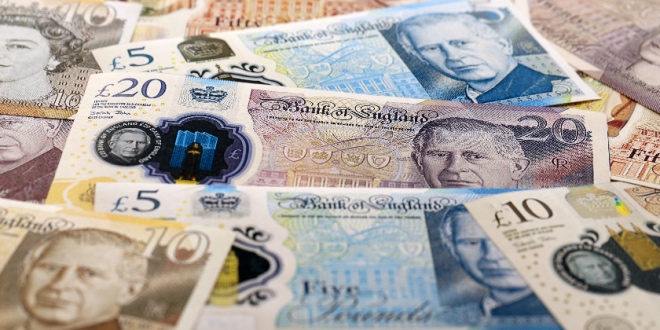 Big pile of British pound money bills on table close up