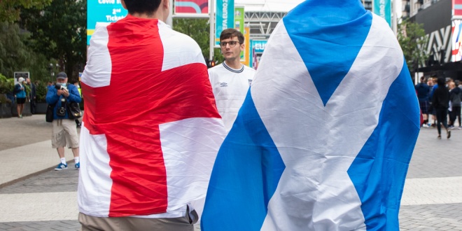 An England fan and Scotland fan side by side wearing their national flags during the Euro 2020 tournament in 2021 - the duo will both feature in this year's World Cup