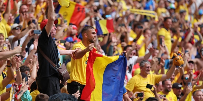 Romanian football fans celebrating in the stands at a game