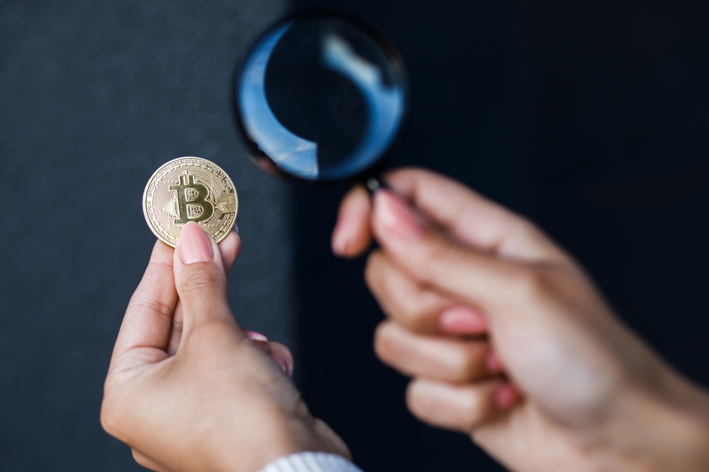 A microscope over a Bitcion, symbolic of GR8_TECH's crypto test