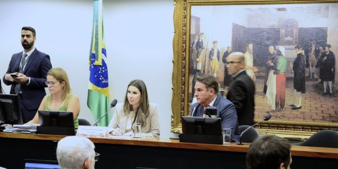 Caroline de Toni (centre, sat to the right of the Brazilian flag)