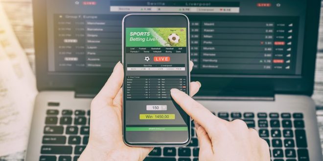 A man using a phone to look at betting odds