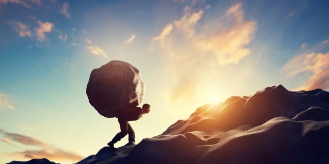A man carrying a boulder, symbolising evoke and Bally's Intralot's debt