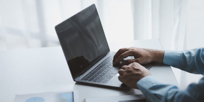 A man working on a laptop and looking at graphs, symbolising iGaming Leader Mastermind's new Chief Growth Officer's remit
