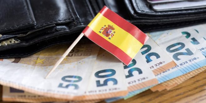 A flag of Spain on top of some euros